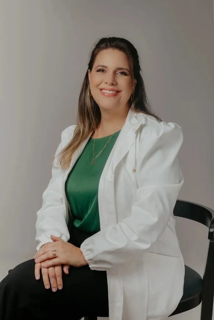 Dra. Juliana Dias sentada, durante atendimento pediátrico na Clínica Majolí